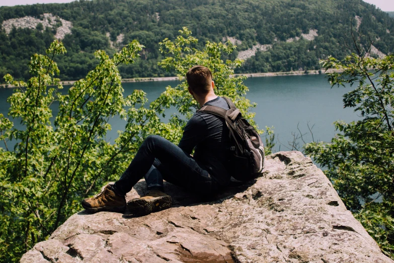 there is a man that is sitting on top of a rock