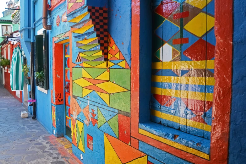 the wall of a building with several colorful paintings on it
