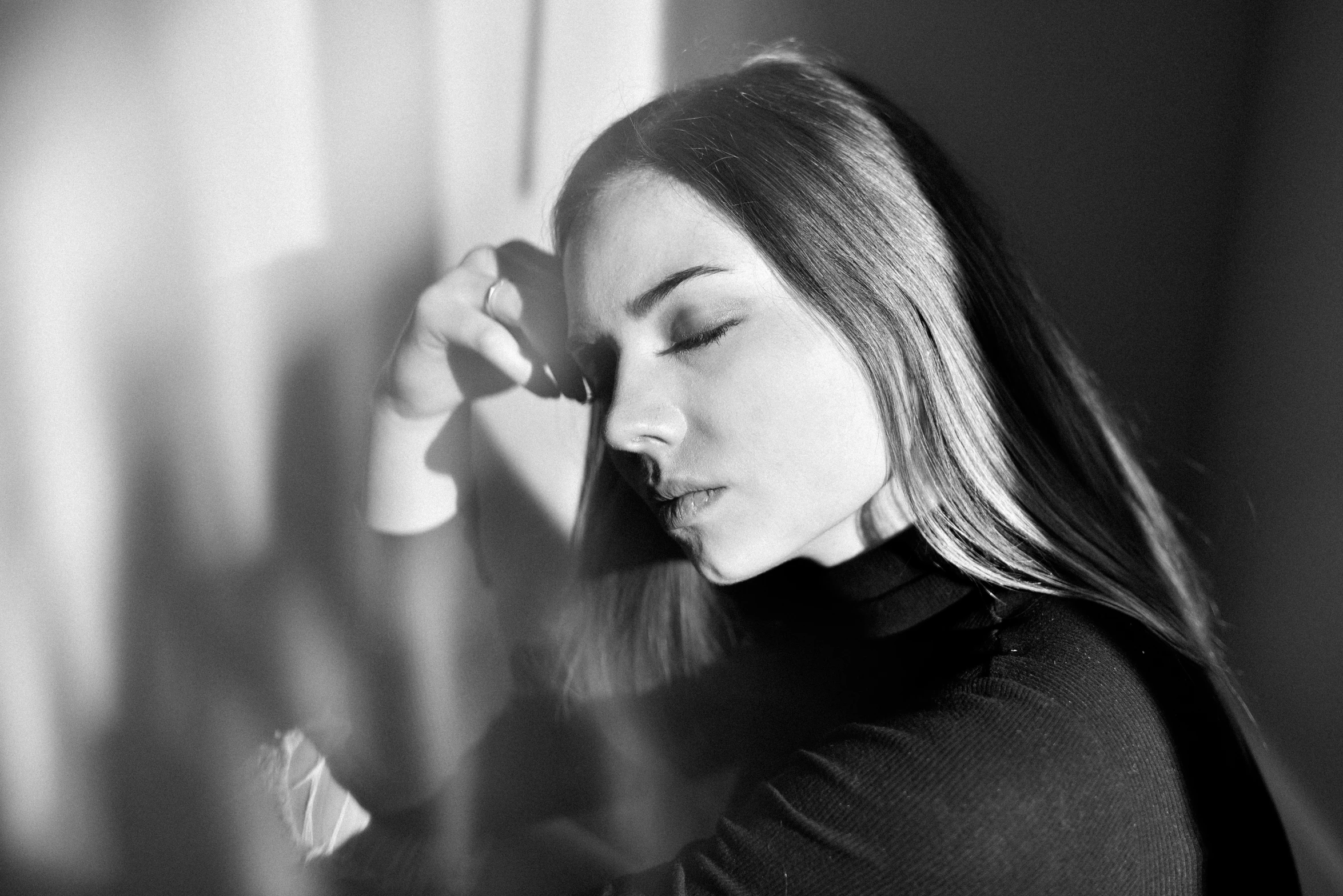 a young woman holds her head and talks on the phone