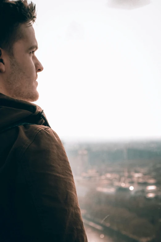 man looking out the window at the city