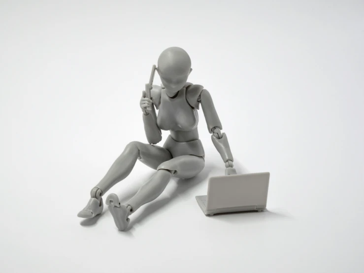 a grey plastic human is sitting and holding a tennis racket