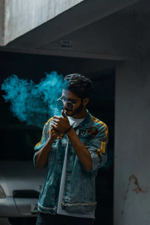 a man is smoking soing while standing next to some concrete building