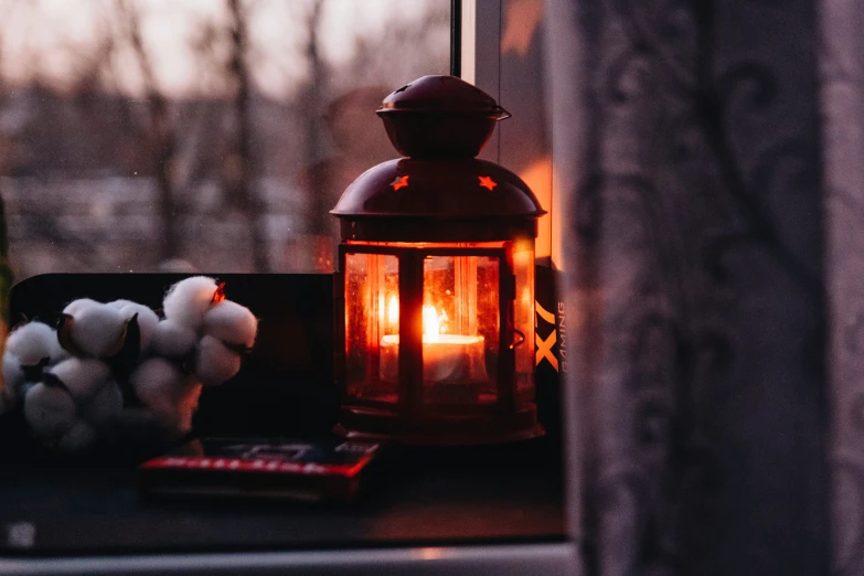 a candle and some other objects are lit on a window sill