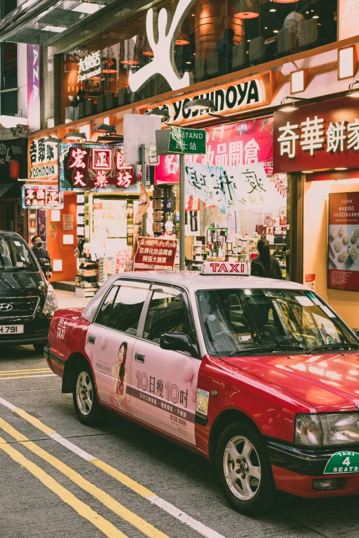 an old red taxi cab driving down a street