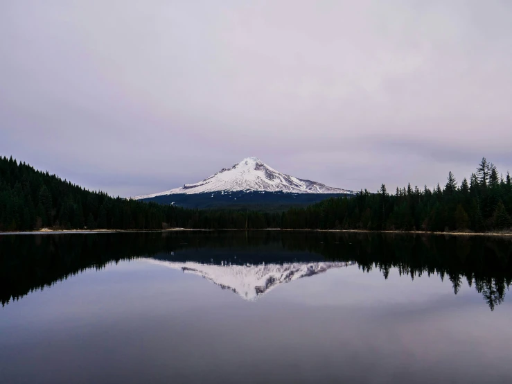 a lake with a snow capped mountain in the distance