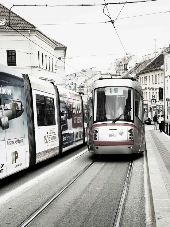 a small car traveling down a street past tall buildings