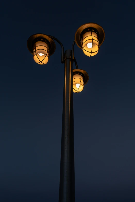 the lights are glowing in the dark on a pole