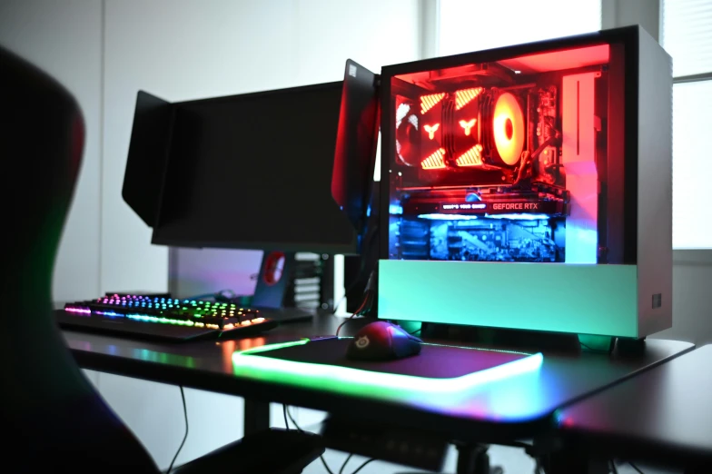 a desk with two computers on it, all lit up