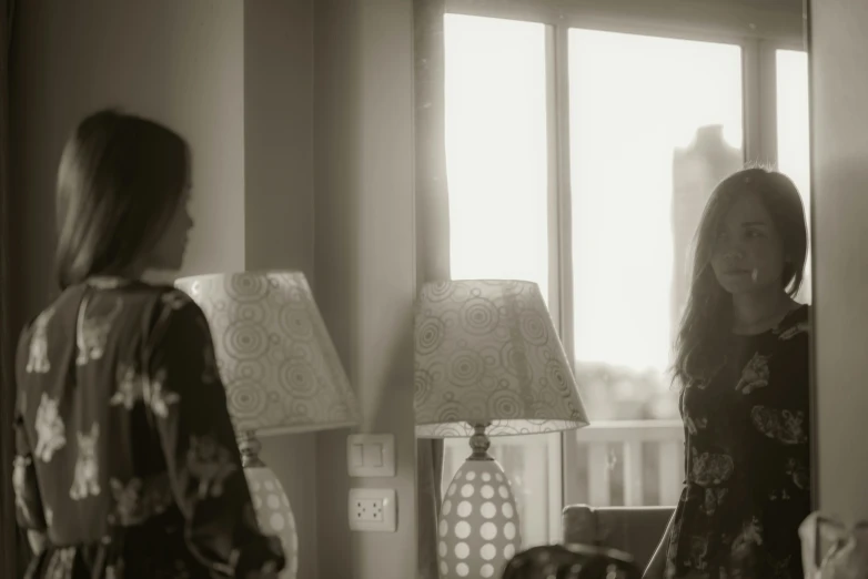 two women standing by a window and talking