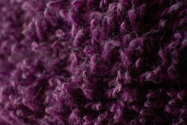 a dark purple background textured with yarn