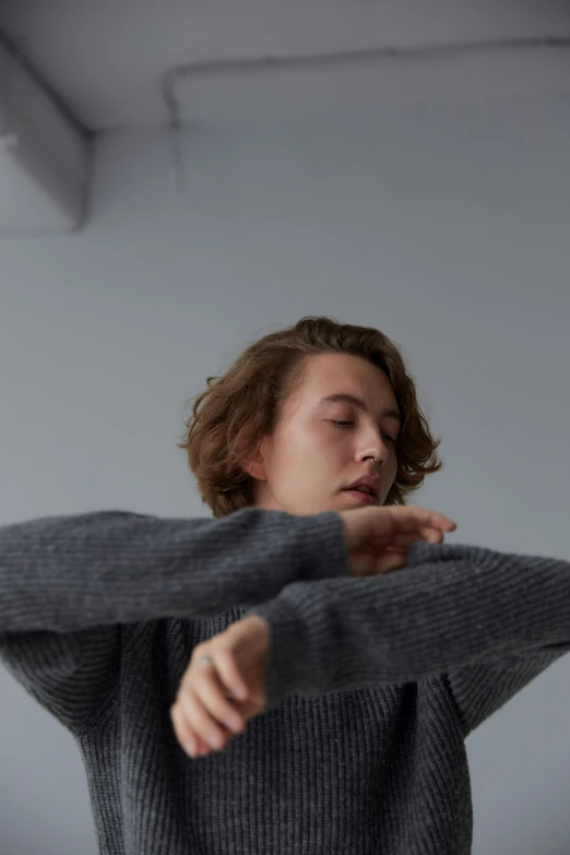 a  wearing a gray sweater is doing exercises