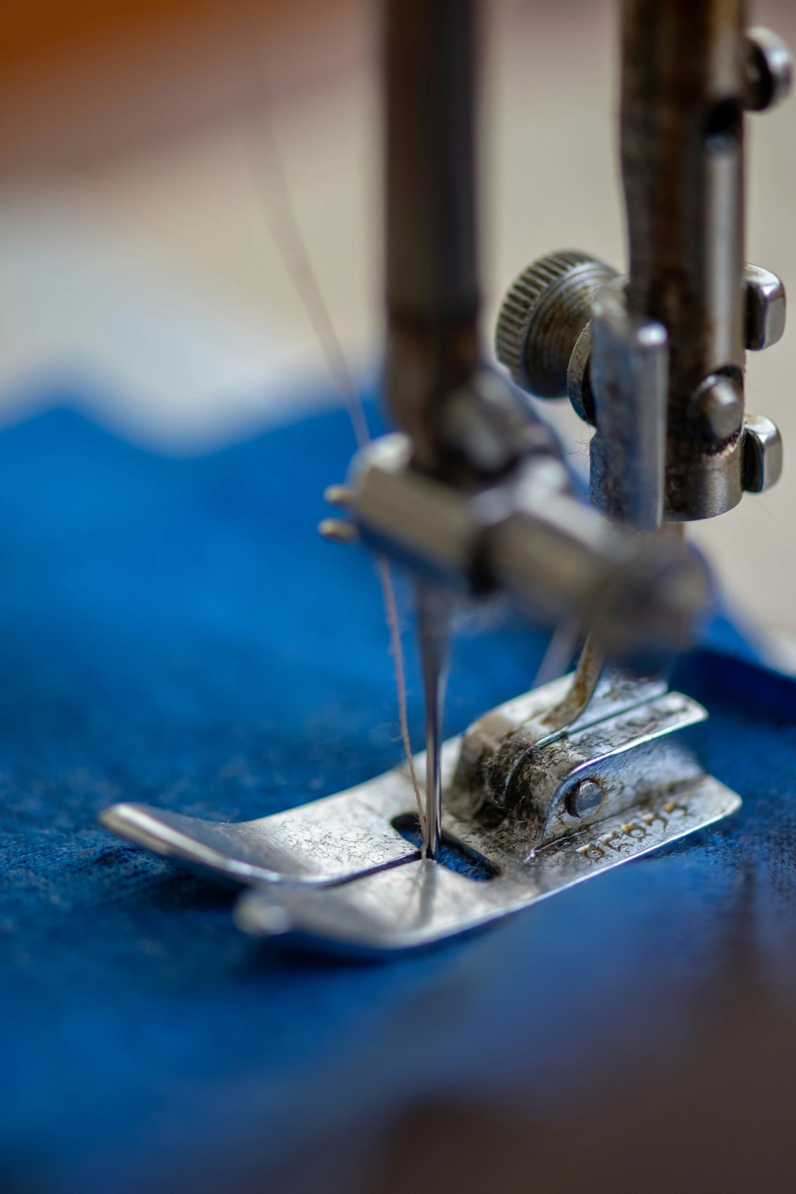 the bottom end of a sewing machine with needles and thread
