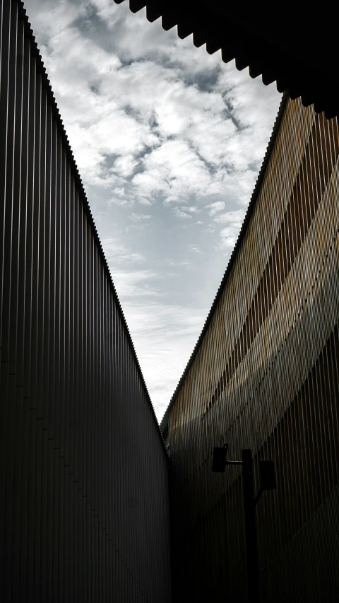 a side view of two tall buildings with a sky background