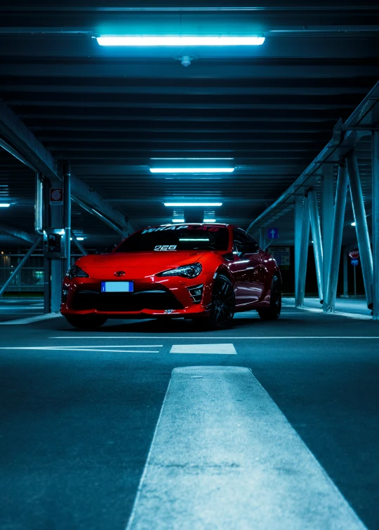 a red sports car is parked in a parking garage