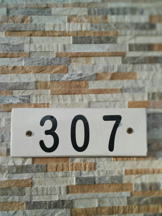 a sign on a brick wall has the number thirty seven