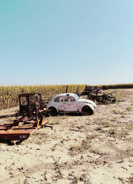 a small vehicle and other vehicles are sitting in the sand