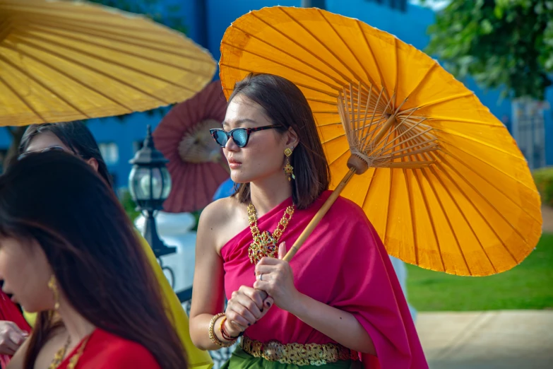 two beautiful women in dresses and umbrellas standing together