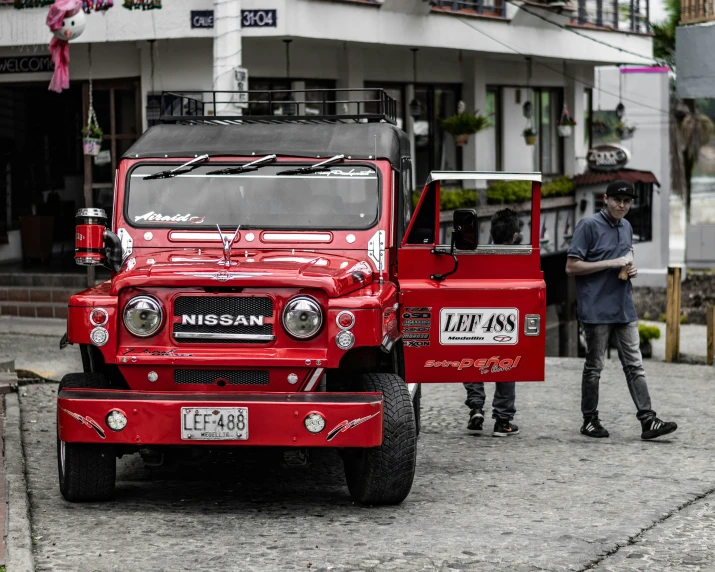 a large red vehicle in front of two men