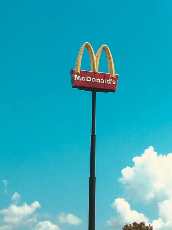 a sign on the side of a street post advertising mcdonald's