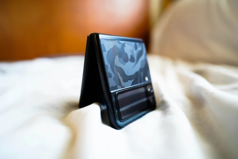 a small tablet is set up on top of a bed