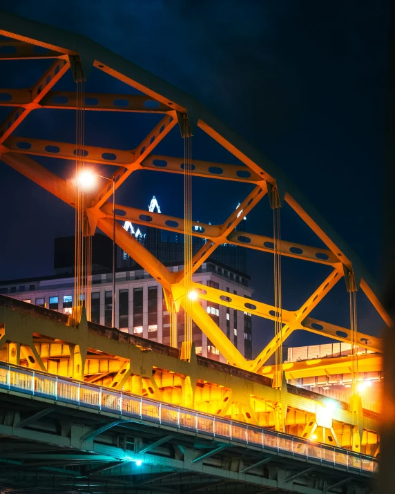 the bridge is made of metal and illuminated at night