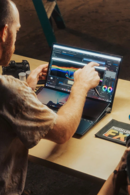 a man is sitting at a table with a laptop