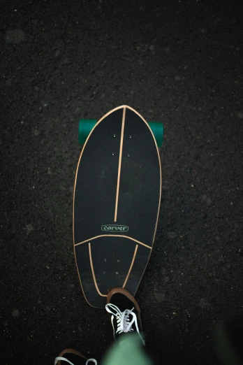 a skateboard laying on the ground next to a persons foot