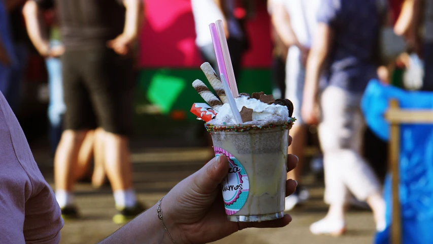 a woman holding a tall glass with ice cream