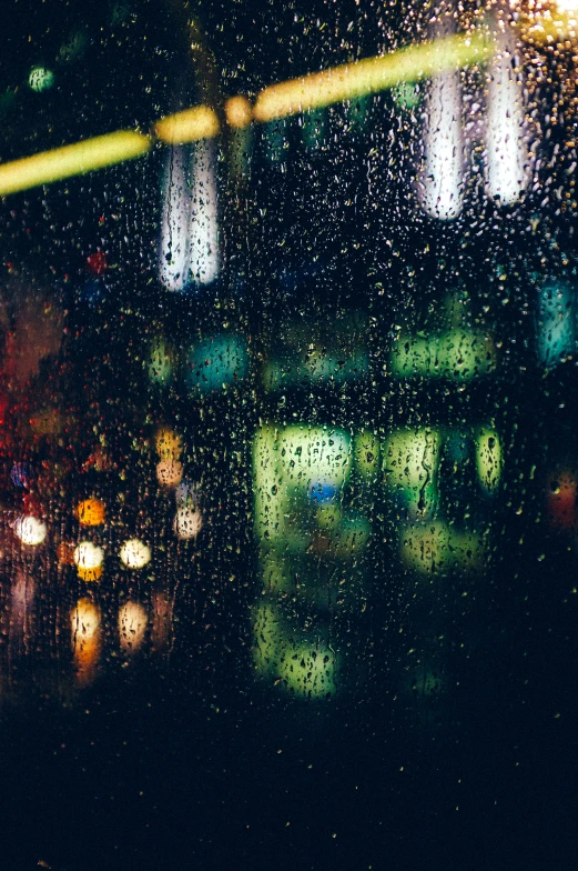 rainy windows overlooking city lights in the dark