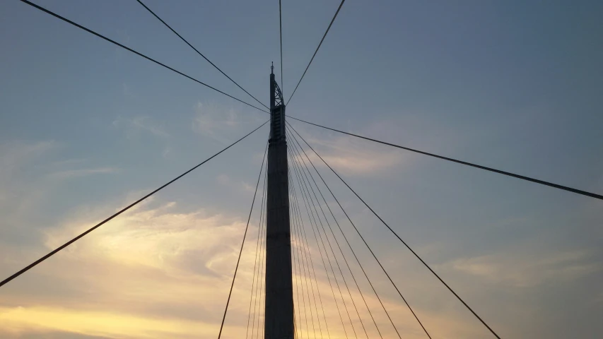 looking up at a tall structure with power lines above it