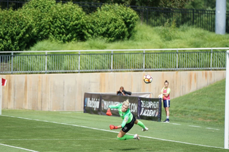 a soccer goalie running towards the ball during a game