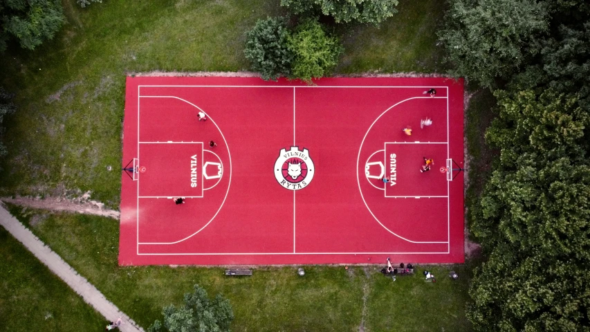 overhead view of a red basketball court in an athletic park