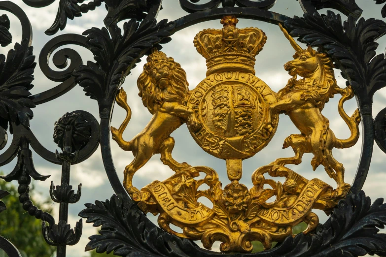 an ornate gold and black fence with two lions