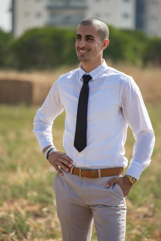 man standing in field wearing dress shirt and tie
