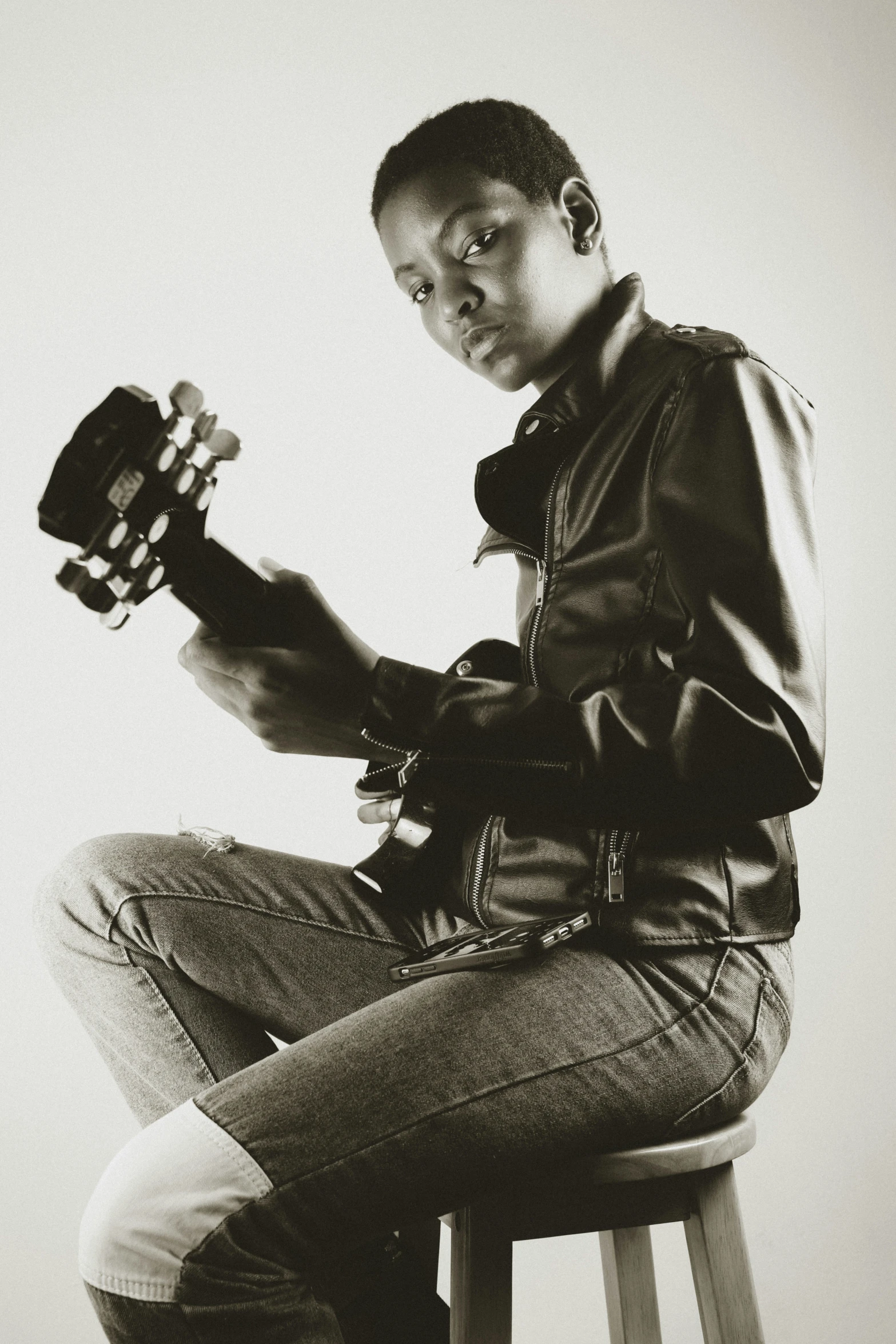 a man sitting on a stool holding a camera