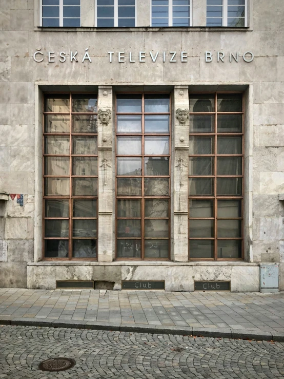 the brick side of an old building has two large windows