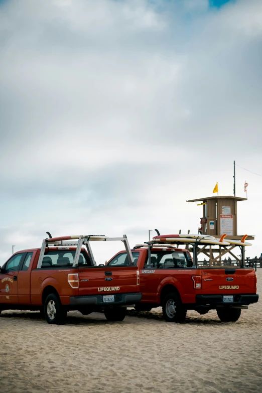 a red truck pulling an suv across the beach