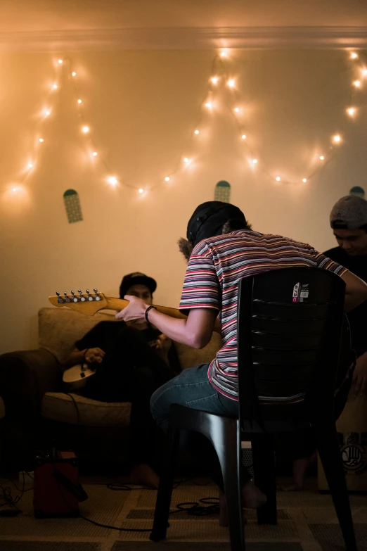 the man is playing guitar at his desk