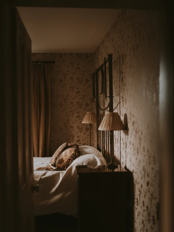 a bed with white sheets, two pillows and a lamp