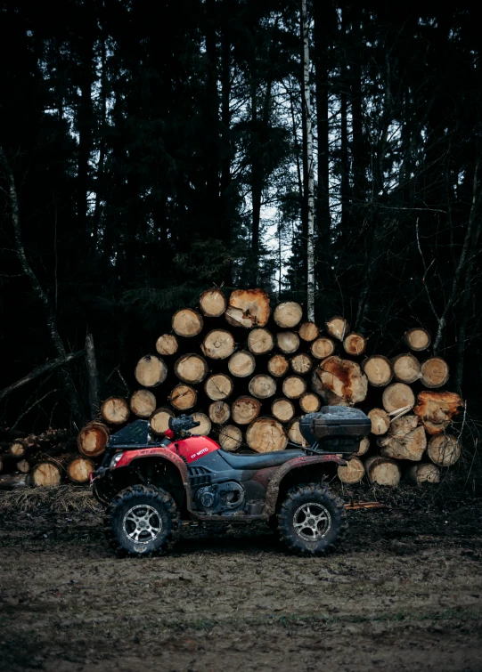 a truck is parked in front of a pile of logs