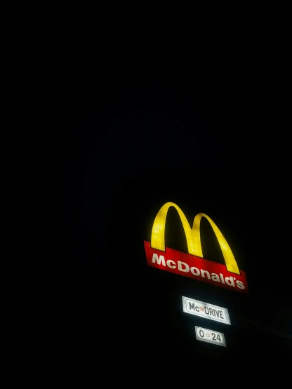 the top of a mcdonalds sign with a very dark background