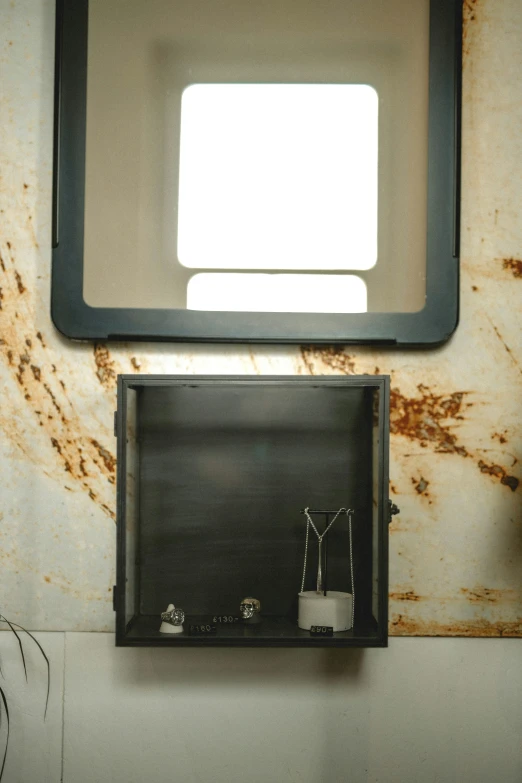 a square shaped mirror that has been partially opened on the wall