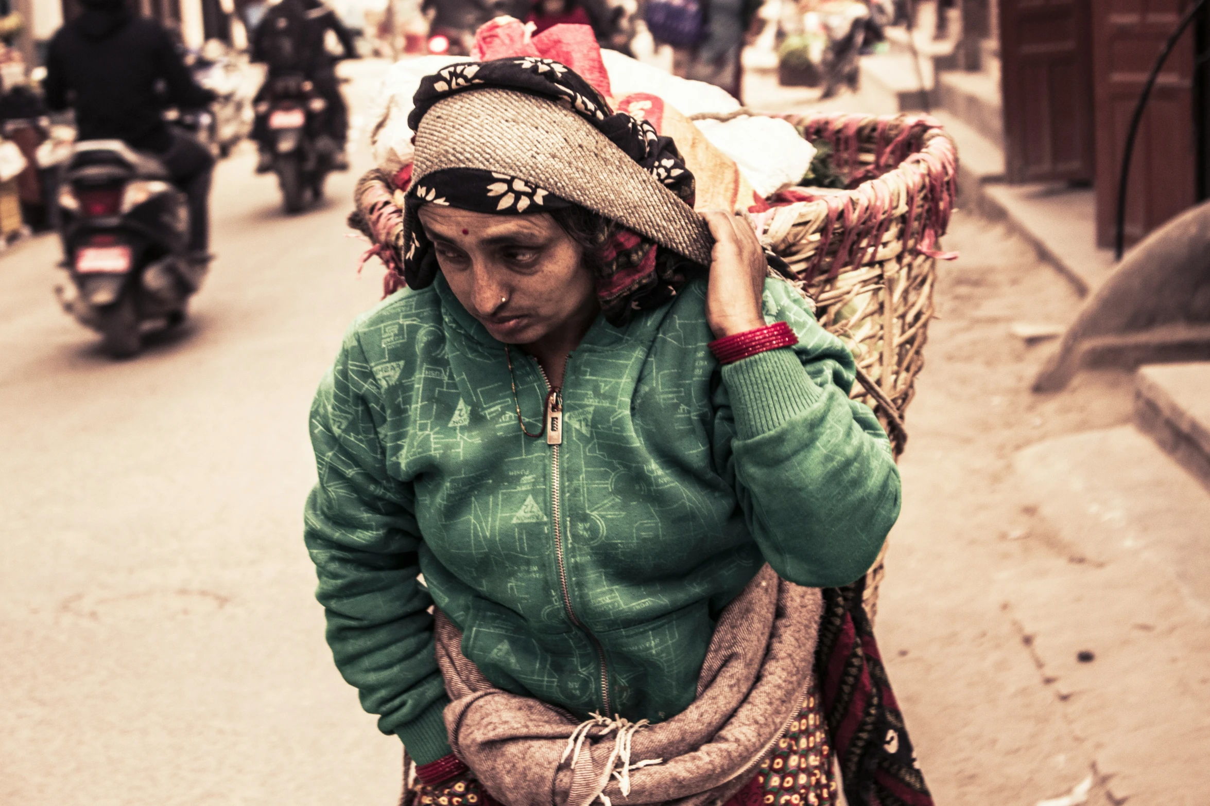 a woman with a straw hat on her head walking down the road