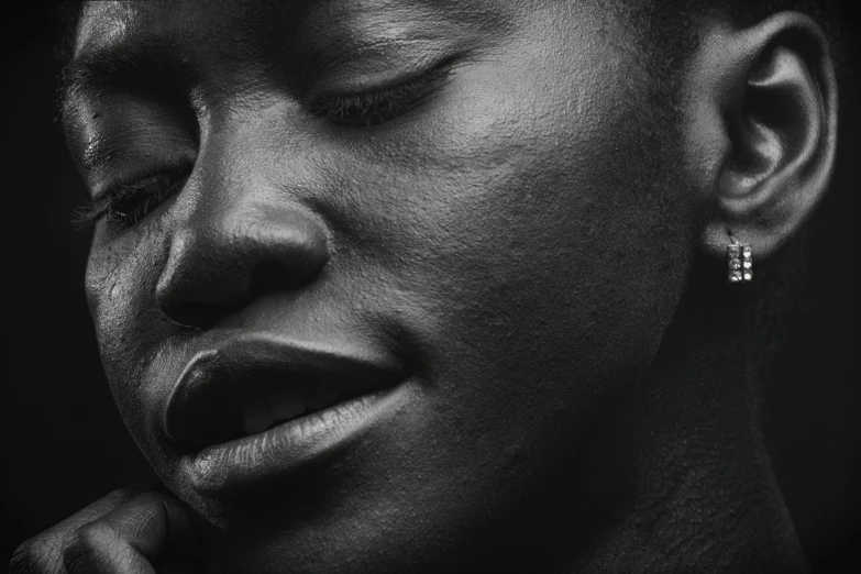 an african woman with a dark background holding her nose in close up