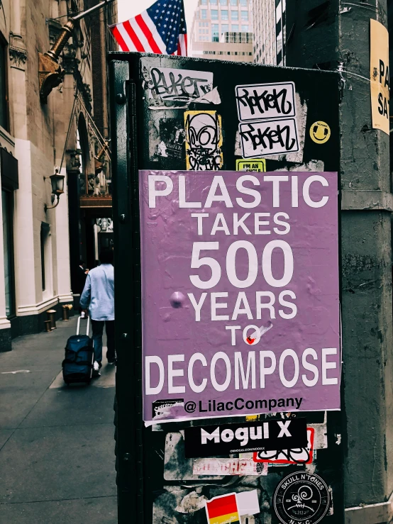 purple sign attached to a building and covered in stickers