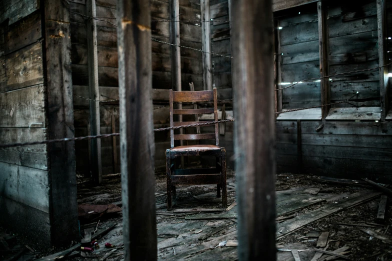 a chair in a room that is boarded up and needs to be cleaned