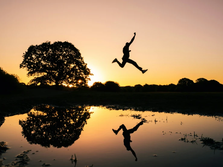 the person jumps in the air above a lake