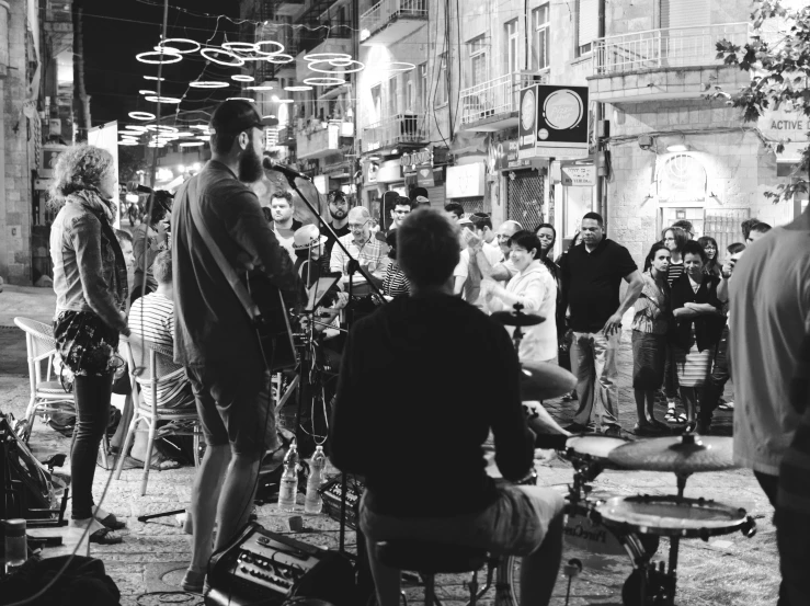 band members gathered at night on the street with a lot of people