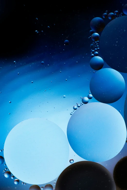 a large amount of bubbles floating in a blue liquid