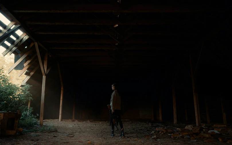 a man standing in an old barn with tall windows